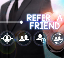 Businessman in a suit pointing at a Refer a Friend button with icons representing social connections.