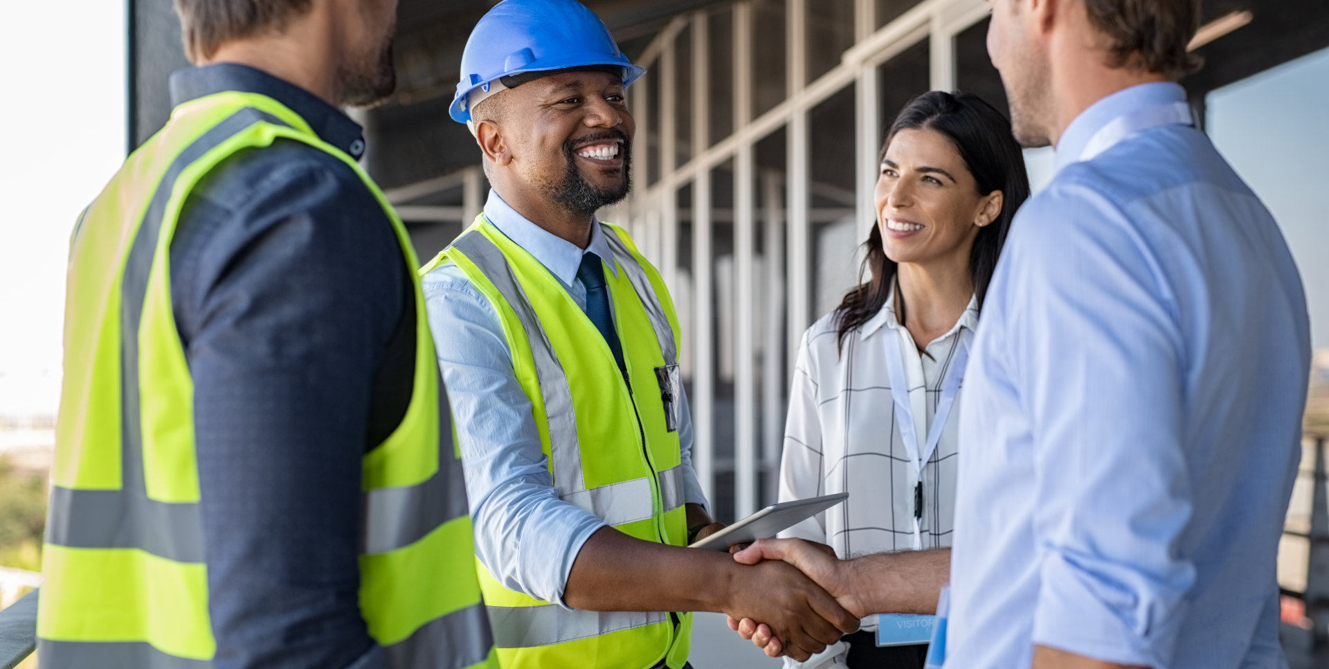 A construction worker and a male shaking their hands