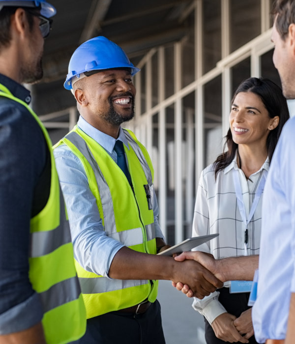 A construction worker and a male shaking their hands