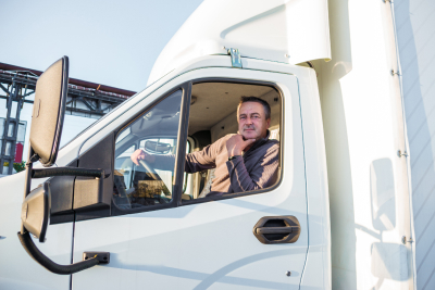 a truck driver sitting in the cab of a white truck